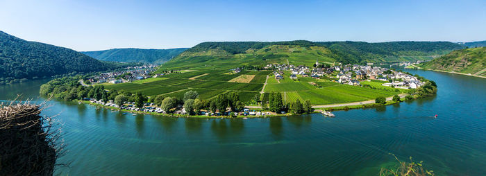 Scenic view of lake and mountains against clear blue sky