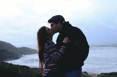 Young couple kissing on shore