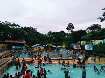 People in swimming pool against sky