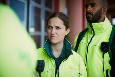 Female paramedic standing with coworker outside hospital