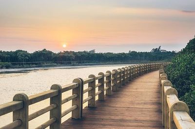 Pier on lake at sunset