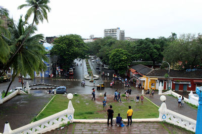 People playing on street in city against sky