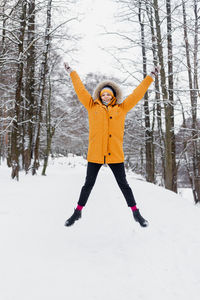 Full length of woman standing on snow covered land