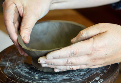 Close-up of person holding clay bowl