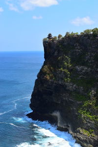 Rock formation by sea against sky