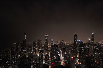 Aerial view of illuminated buildings in city at night