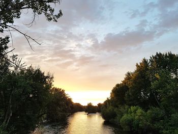 Scenic view of river against sky at sunset