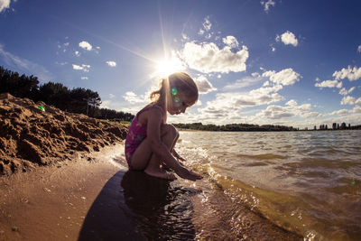 Side view of boy on beach against sky