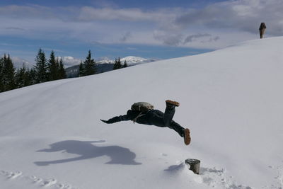 Person falling on snow covered landscape during winter
