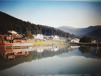 Scenic view of lake by mountains against clear sky