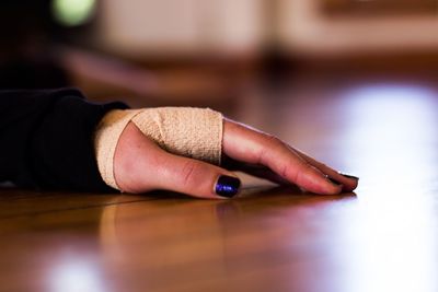 Close-up of woman hand with bandage on table