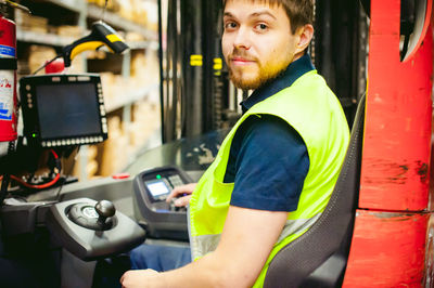 Worker driving forklift in factory