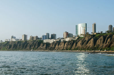 Modern buildings in city against clear sky