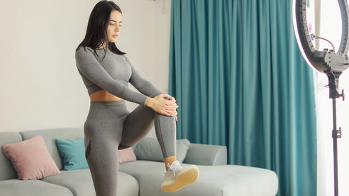 Young woman sitting on bed at home