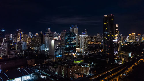 Illuminated buildings in city against sky at night