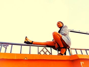 Low angle view of woman on boat against clear sky
