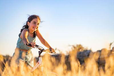 Cute girl with her bike at summer.