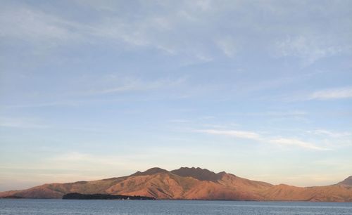 Scenic view of sea and mountains against sky