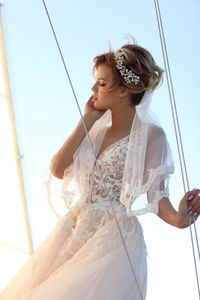 Bride on a sailing yacht against the background of a blue sky
