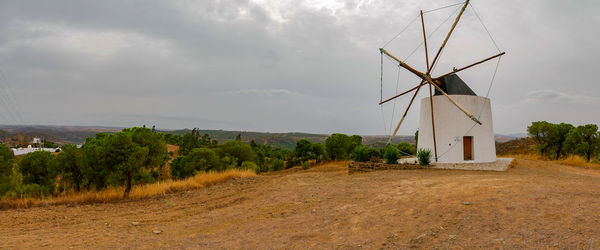 Traditional windmill on field against sky