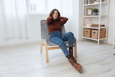 Young woman sitting on sofa at home