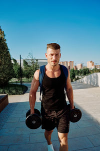 Portrait of young man exercising in gym