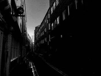 Low angle view of footpath amidst buildings in city