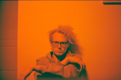 Portrait of man against orange wall