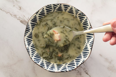Eating portuguese kale soup called caldo verde
