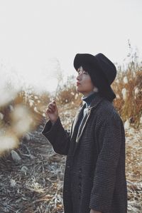 Side view of young man standing in snow