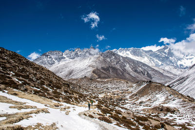 Scenic view of snowcapped mountains against blue sky