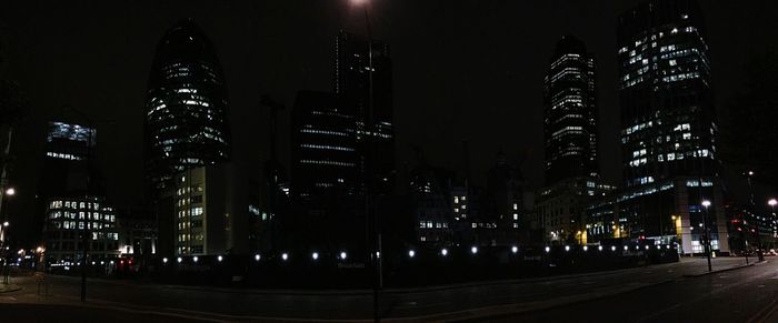 Illuminated buildings against sky at night