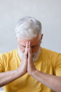 Mature man meditating at home