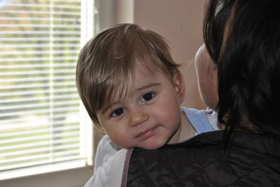 Portrait of smiling boy with mother at home