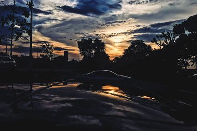 Cars on road against sky during sunset