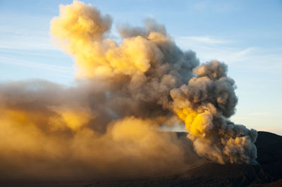 Smoke emitting from volcano against sky