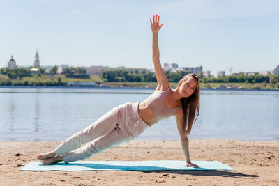 Middle aged woman in sportswear doing yoga exercise. stretching woman outdoor. side plank asana