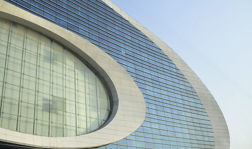 Low angle view of glass building against sky