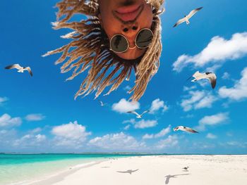 Low angle view of seagulls flying over man's head