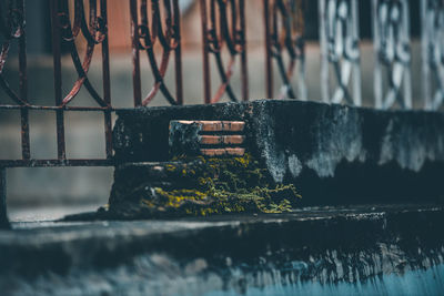 Close-up of rusty metal fence against wall