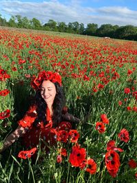 Portrait of woman standing amidst yellow flowering plants on field