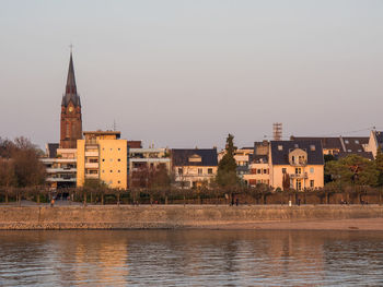 River by buildings against clear sky