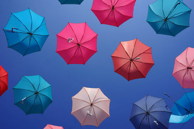 Directly below shot of colorful umbrellas against clear blue sky