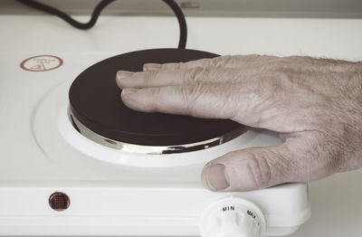 Cropped image of hand pushing switch of electrical equipment