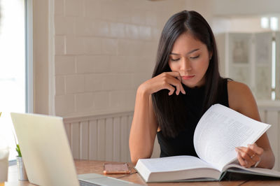Young woman sitting on book