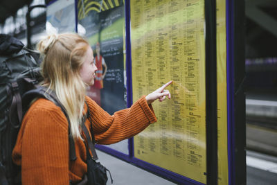 Woman on train station checking timetable