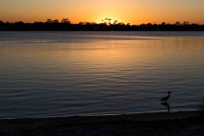 Scenic view of lake against orange sky