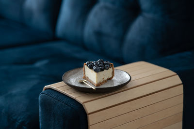 A piece of blueberry cheesecake and a cup of coffee on the couch. cozy room with a reading nook