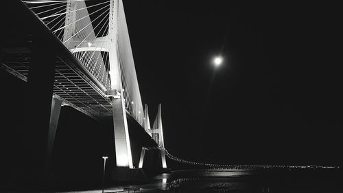 Low angle view of illuminated bridge against sky at night