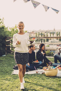 Portrait of happy woman with breakfast walking at rooftop party